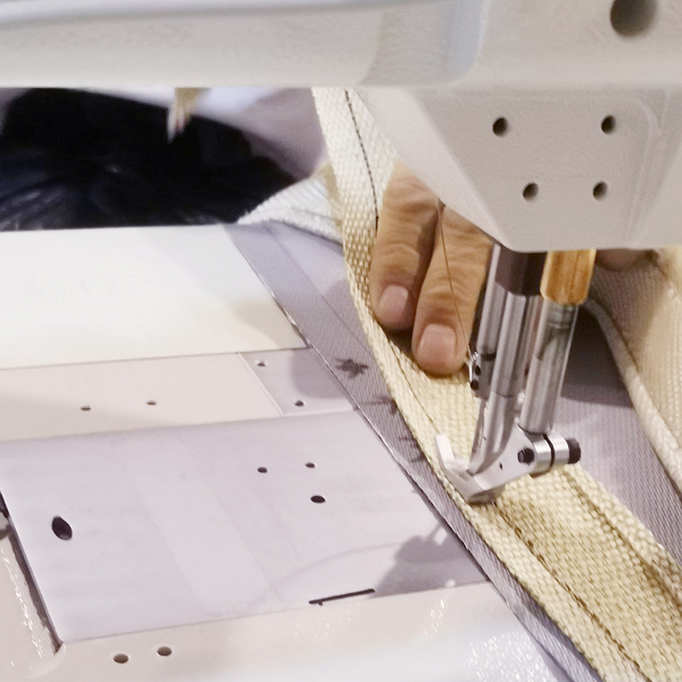 Photo of a person sewing insulation jackets